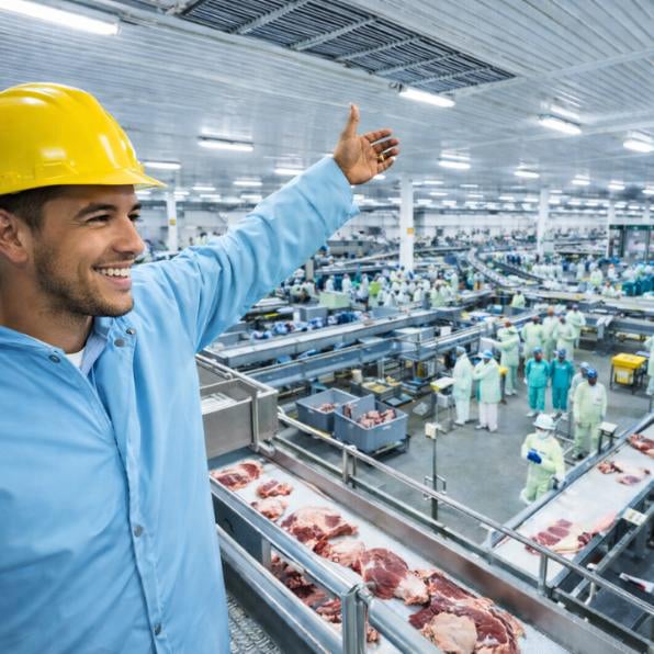 Profissional com capacete em ambiente industrial de frigorífico